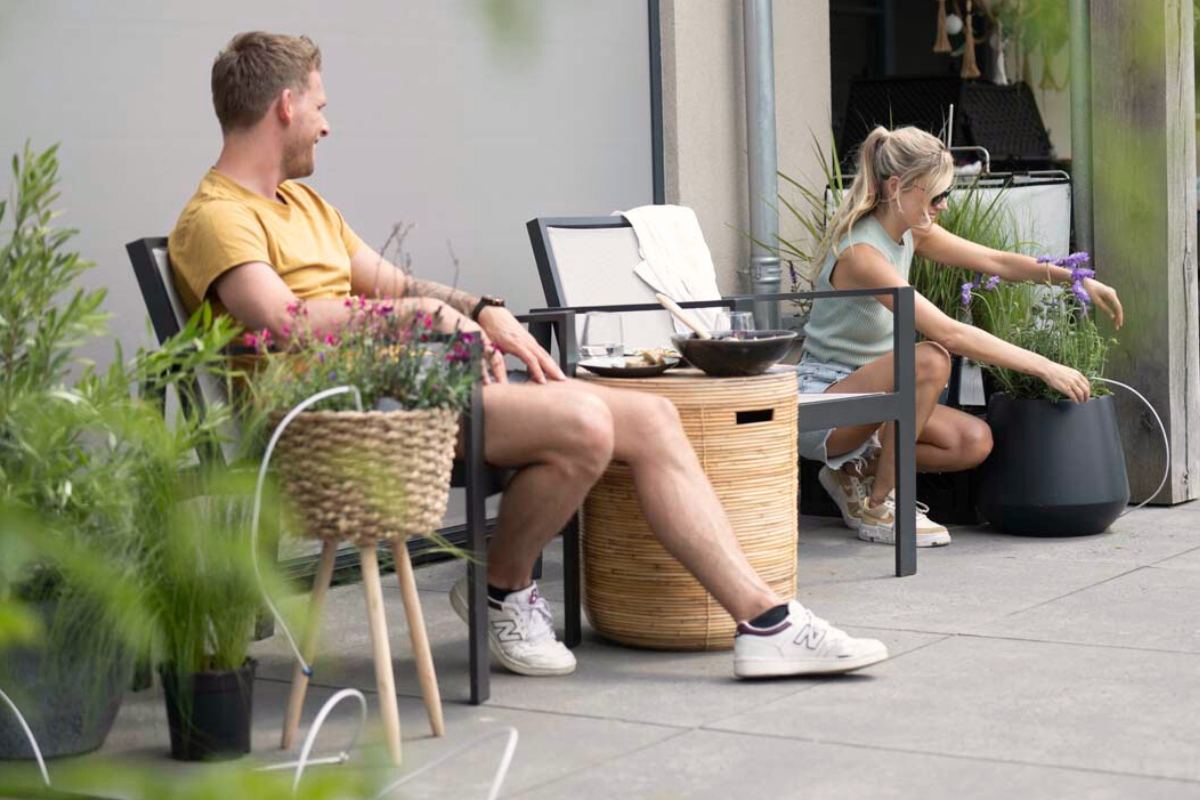 Druppelset voor bloempotten in werking met twee mensen op een terras